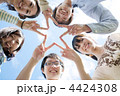 手を合わせ星型を作る5人の若者たち
