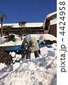 雪下ろしをする老婦人