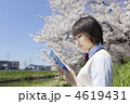 土手に座り参考書を読む女子高校生