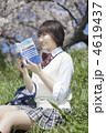 土手に座り参考書を読む女子高校生