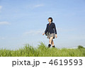 土手を歩く女子高校生