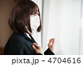 窓の向こうを見つめるマスクをしたビジネスウーマン
