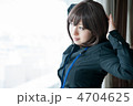 窓の向こうを見つめながらストレッチするビジネスウーマン