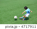 ユニフォームを着たサッカー少年のダイナミックなシュートシーン