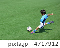 ユニフォームを着たサッカー少年のダイナミックなシュートシーン