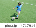 ユニフォームを着たサッカー少年のダイナミックなシュートシーン