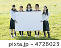 草原でメッセージボードを持つ中学生