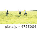風船を持ち草原を走る中学生