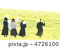 風船を持ち草原を歩く中学生の後姿