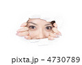 壁をこじ開け先を見つめる女性の写真素材