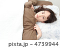 ベッドの布団の中で横になっている若い女性