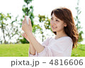 芝生で携帯を使う女性