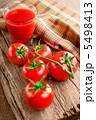Tomato juice in glass and fresh tomatoes on vintage wooden cutti