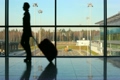 silhouette of woman walks against window at airport
