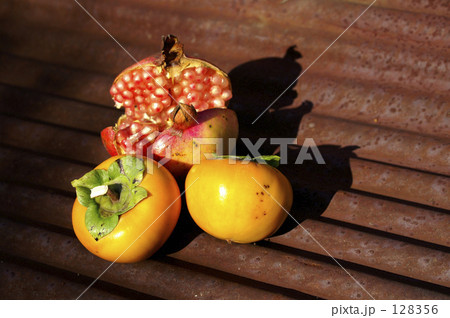 トタン板の上に置かれたもぎたて柘榴と柿 128356