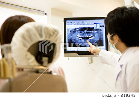 レントゲン写真を説明する歯科医 レントゲン写真を説明する歯科医 319245