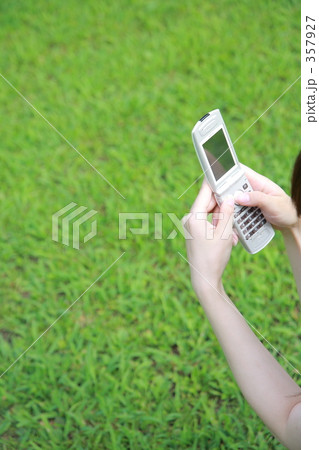 携帯を持つ手と芝生 357927
