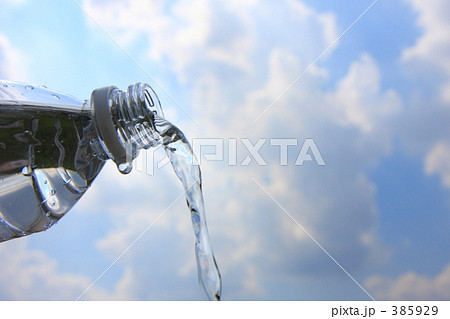 青空とペットボトルから流れる水の写真素材