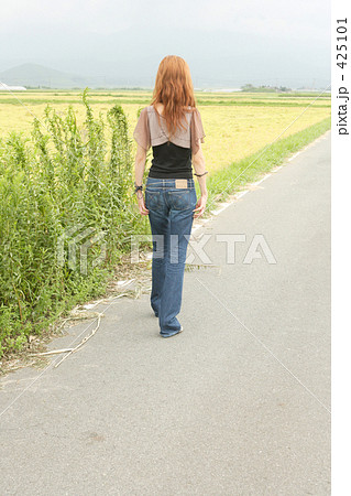 女性 後ろ姿 道の写真素材