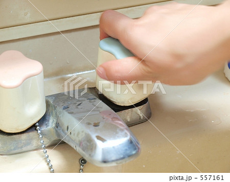 洗面所の蛇口をしめる手の写真素材