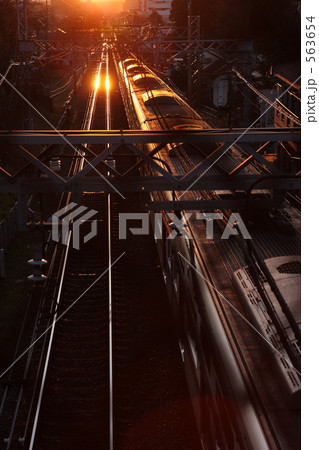 夕日の中を走る通勤列車 563654