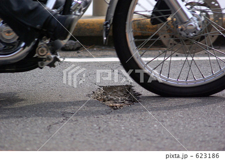 道路のポットホールの上を走るバイク 道路のポットホールの上を走るバイク 623186