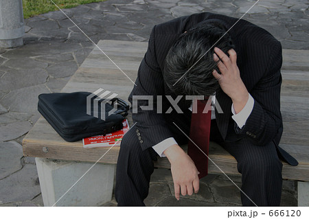 ベンチに座って悩む中年男性 666120