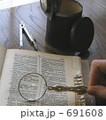 古い拡大鏡で辞書を調べる 691608