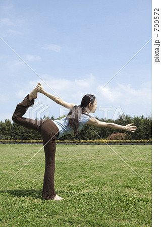 芝生でヨガをする女性 700572