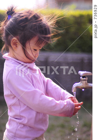 風の強い夕方公園の水道で手を洗う１歳の子供 736929