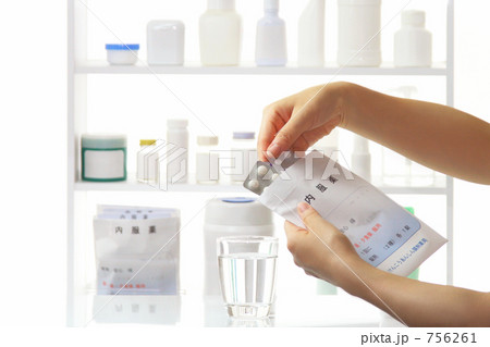 薬局　調剤薬局イメージ　薬袋からクスリを出して確認する女性の手 756261