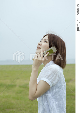 草原で電話する女性 780619