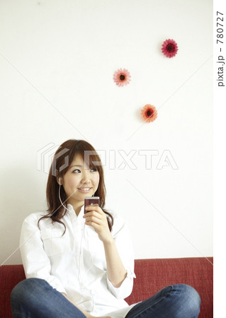 ソファーに座り音楽を聴く女性 780727