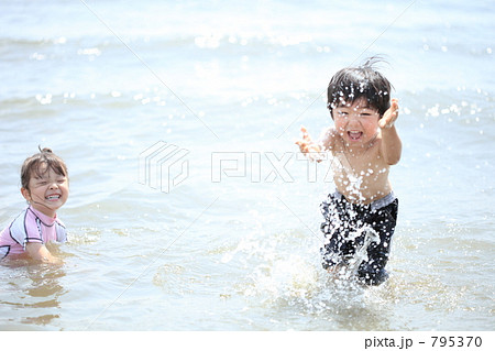 海水浴で水をかける幼い兄弟 795370