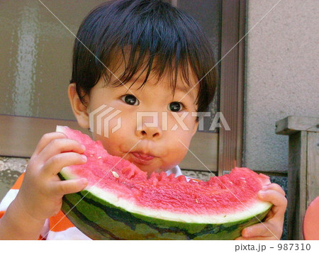 庭先で、夏の暑い日にスイカを食べる 庭先で、夏の暑い日にスイカを食べる 987310