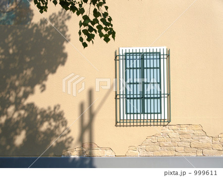 ベージュ色の壁と水色の格子窓 999611