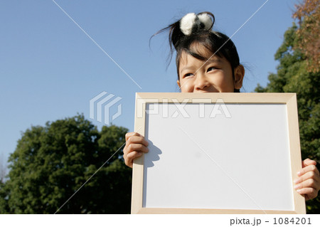笑顔でメッセージボードを持つ女の子 1084201