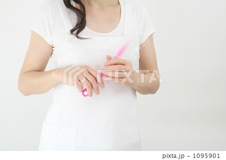 ピンクのヘラを持つ白いエプロンの女性　１ 1095901