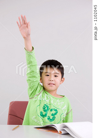 手を挙げる男の子 小学2年生 の写真素材