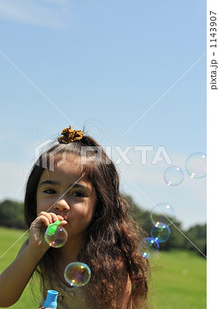 シャボン玉をするハーフの女の子の写真素材