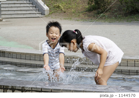 水遊びに興じる姉弟の写真素材