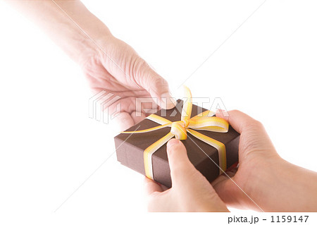 プレゼントを手渡す男女の手の写真素材