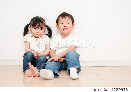床に座る子供カップルの写真素材