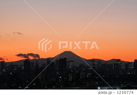 夕焼けに浮かぶ富士山のシルエットと東京の街並みの写真素材