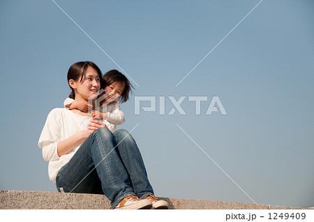 土手に座る笑顔の母親と娘 土手に座る笑顔の母親と娘 1249409