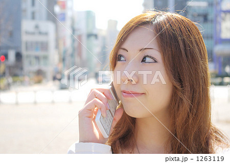 町並みをバックに電話で話す女性 町並みをバックに電話で話す女性 1263119