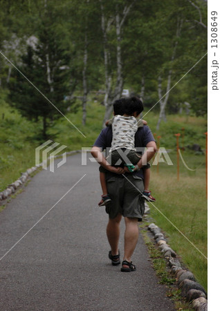小さい息子をおんぶして歩く父親の後ろ姿 小さい息子をおんぶして歩く父親の後ろ姿 1308649