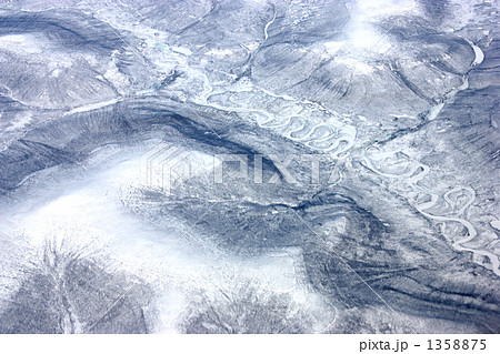 ヨーロッパ行きの飛行機の窓からツンドラの氷河を見下ろすの写真素材