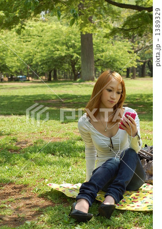 芝生の上で音楽を聴く女性 1389329