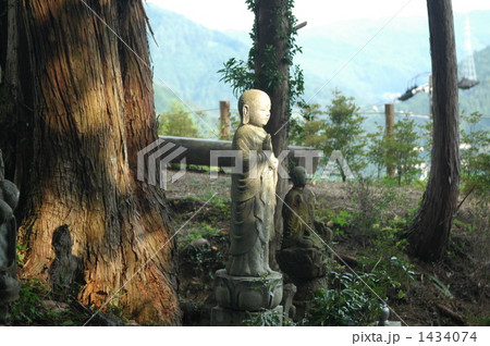 森林の中にひっそりとたたずむ地蔵菩薩に光がさしこむ 森林の中にひっそりとたたずむ地蔵菩薩に光がさしこむ 1434074